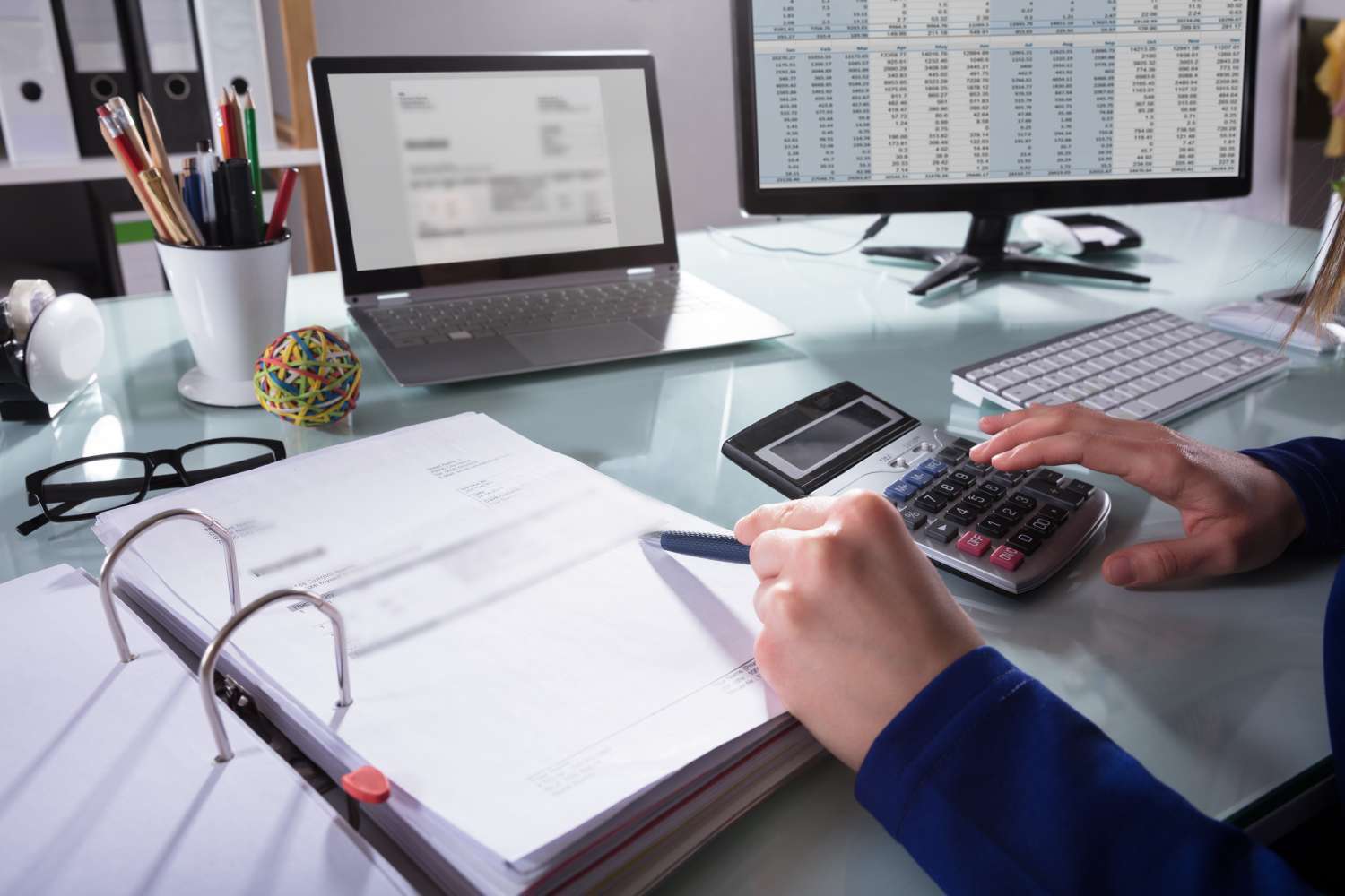 Close-up,Of,A,Businessperson’s,Hand,Calculating,Invoice,At,Workplace